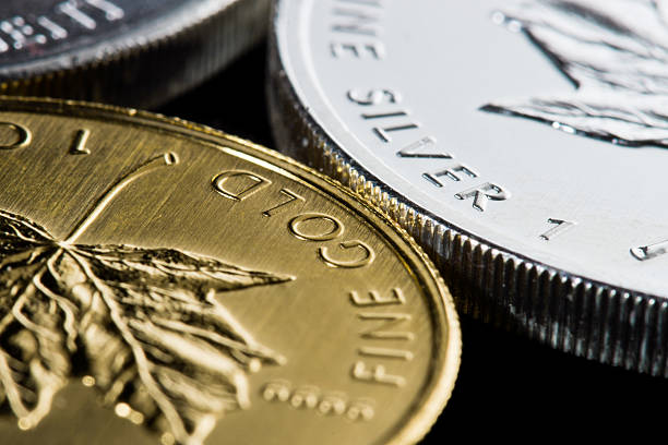 A Canadian Gold maple leaf and Canadian Silver maple leaf coins.